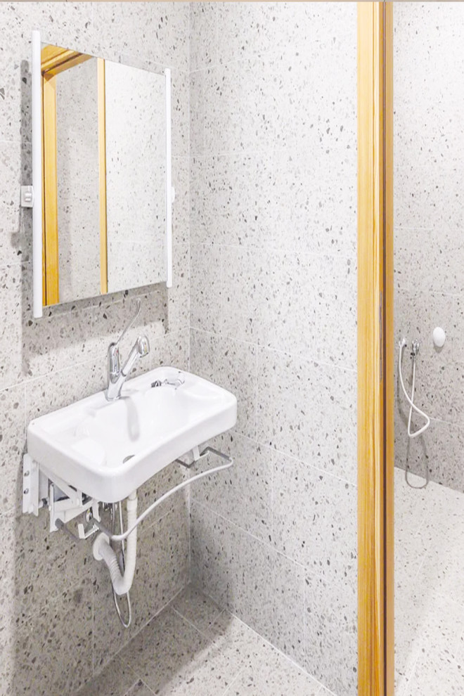 Bild på ett stort vit vitt en-suite badrum, med ett platsbyggt badkar, en öppen dusch, en toalettstol med hel cisternkåpa, grå kakel, cementkakel, vita väggar, terrazzogolv, ett nedsänkt handfat, vitt golv och med dusch som är öppen