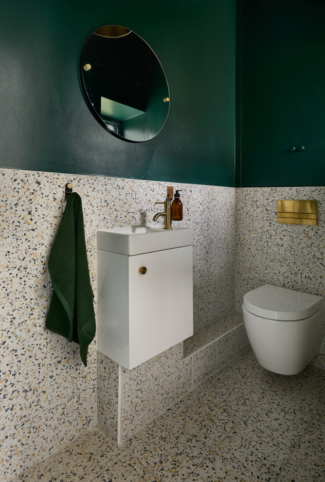 Small trendy powder room photo in London with flat-panel cabinets, green cabinets and a wall-mount toilet