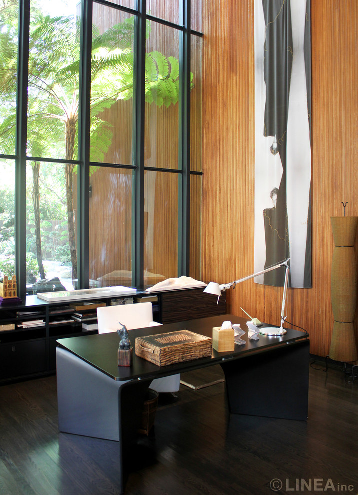 Large midcentury study room in Los Angeles with dark hardwood floors and a freestanding desk.