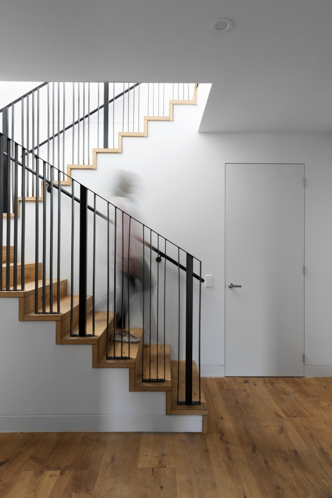 Mid-sized contemporary wood u-shaped staircase in Melbourne with wood risers and metal railing.