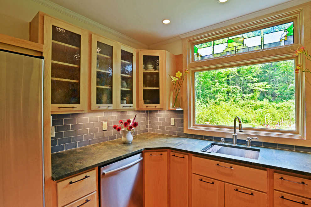 Example of an eclectic u-shaped medium tone wood floor kitchen design in Boston with an undermount sink, glass-front cabinets, light wood cabinets, granite countertops, blue backsplash, ceramic backsplash, stainless steel appliances, no island and green countertops