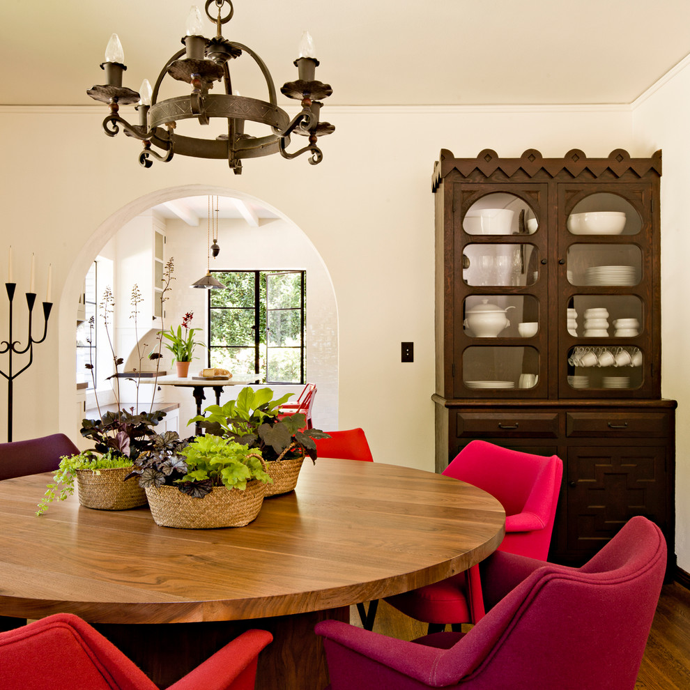 This is an example of a mediterranean dining room in Portland with white walls and dark hardwood floors.