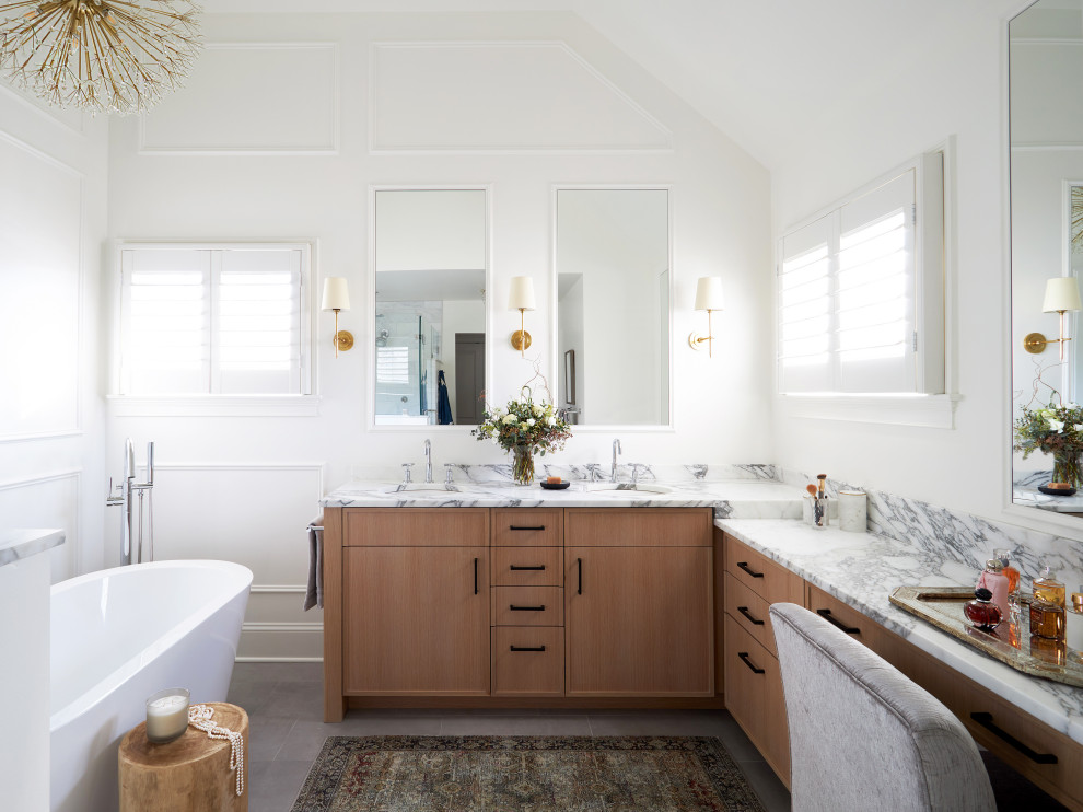 На фото: большая главная ванная комната в белых тонах с отделкой деревом в стиле модернизм с плоскими фасадами, светлыми деревянными фасадами, отдельно стоящей ванной, двойным душем, унитазом-моноблоком, разноцветной плиткой, мраморной плиткой, белыми стенами, полом из керамогранита, накладной раковиной, мраморной столешницей, серым полом, душем с распашными дверями, разноцветной столешницей, сиденьем для душа, тумбой под две раковины, встроенной тумбой и сводчатым потолком с
