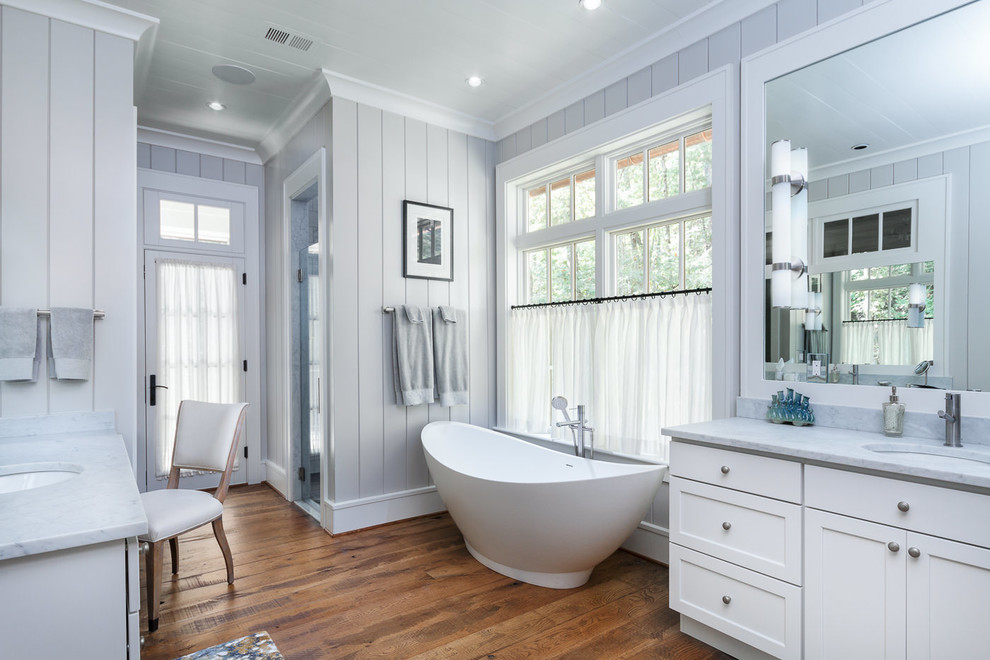 Inspiration for a country master bathroom in Other with shaker cabinets, white cabinets, a freestanding tub, grey walls, medium hardwood floors and an undermount sink.