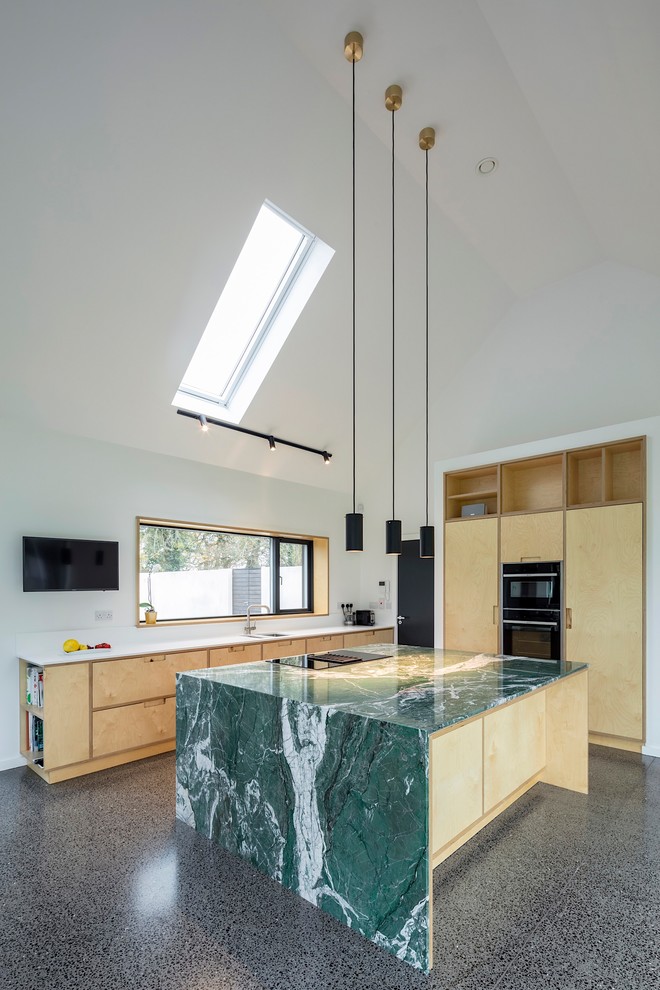 Inspiration for a large contemporary l-shaped open plan kitchen in Other with an integrated sink, flat-panel cabinets, light wood cabinets, marble benchtops, white splashback, stone slab splashback, panelled appliances, concrete floors, with island, grey floor and green benchtop.