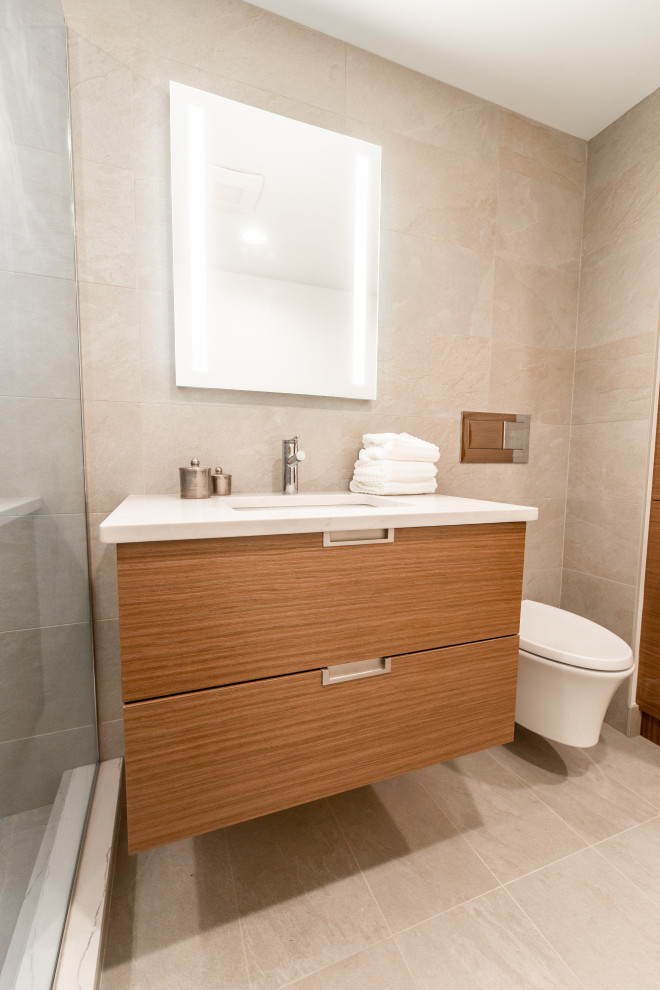 Bathroom - small modern 3/4 beige tile and porcelain tile porcelain tile, beige floor and single-sink bathroom idea in Milwaukee with flat-panel cabinets, medium tone wood cabinets, a one-piece toilet, beige walls, an undermount sink, quartz countertops, white countertops and a floating vanity