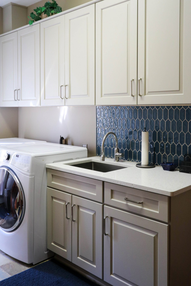 Small transitional single-wall dedicated laundry room in Cleveland with an undermount sink, raised-panel cabinets, white cabinets, quartz benchtops, blue splashback, cement tile splashback, grey walls, a side-by-side washer and dryer and white benchtop.