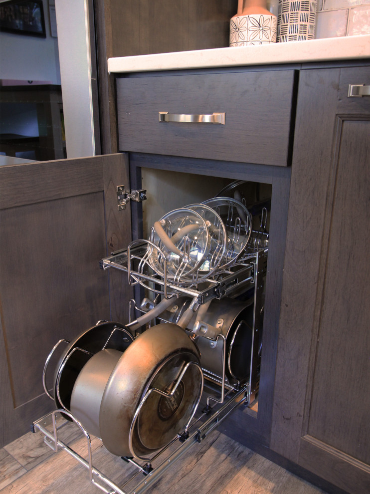 Example of a mid-sized transitional galley laminate floor and brown floor enclosed kitchen design in Boise with a farmhouse sink, flat-panel cabinets, dark wood cabinets, quartz countertops, multicolored backsplash, porcelain backsplash, stainless steel appliances and white countertops
