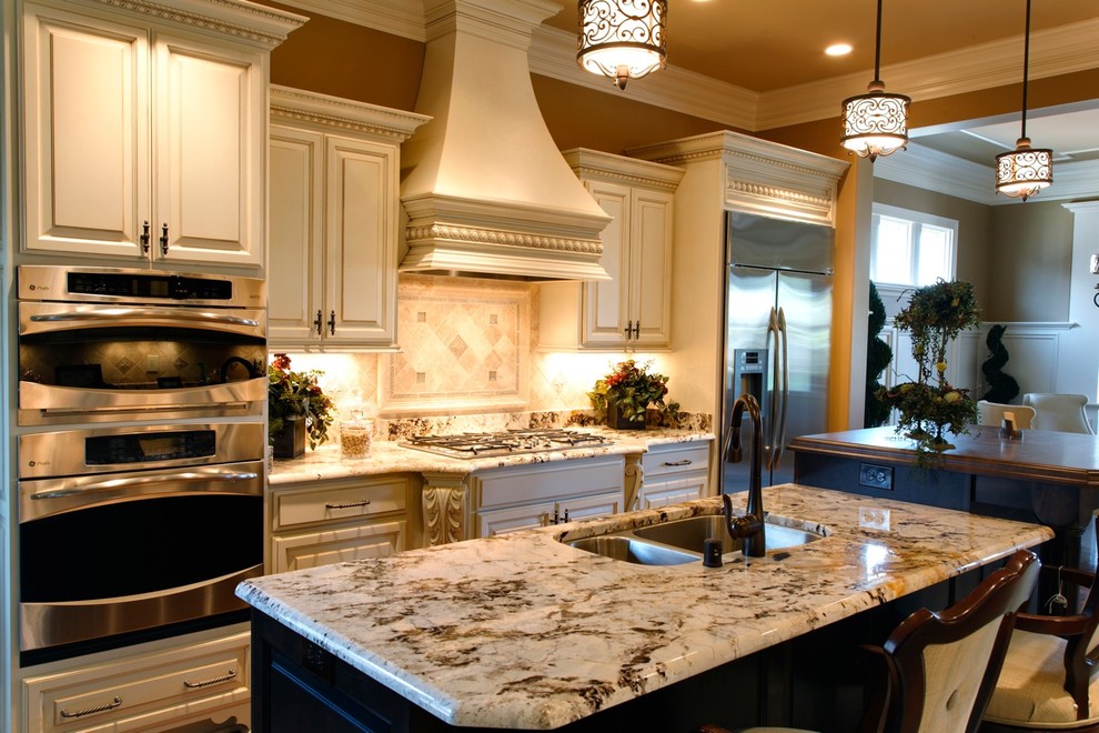 Traditional kitchen in Louisville with a double-bowl sink, raised-panel cabinets, beige cabinets, beige splashback and stainless steel appliances.