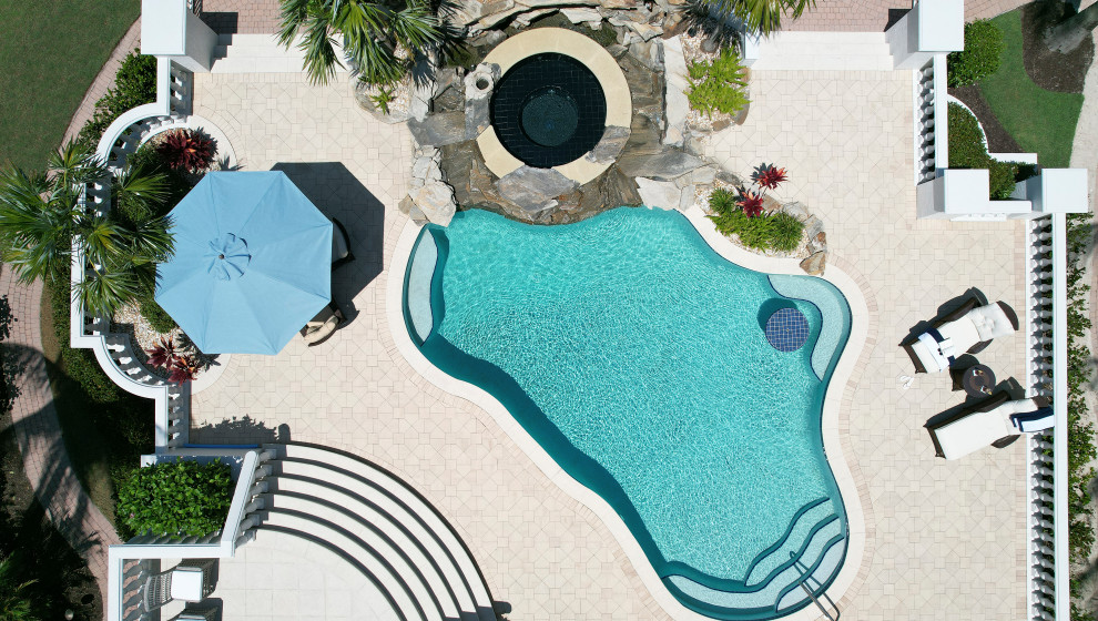 Inspiration for a large transitional backyard concrete paver and custom-shaped pool landscaping remodel