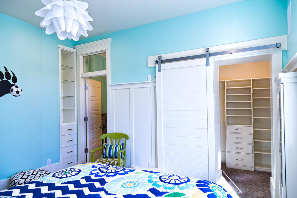 This is an example of an expansive arts and crafts kids' room for girls in Salt Lake City with blue walls and carpet.