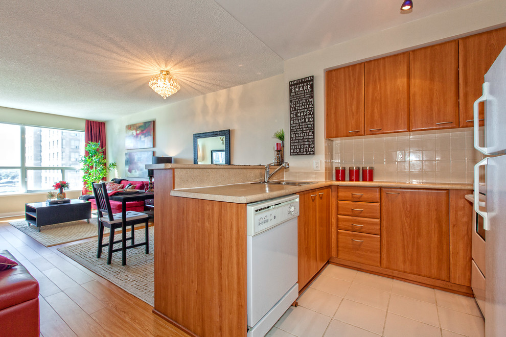 Example of a small transitional u-shaped ceramic tile eat-in kitchen design in Toronto with a drop-in sink, flat-panel cabinets, medium tone wood cabinets, solid surface countertops, white backsplash, subway tile backsplash, white appliances and a peninsula