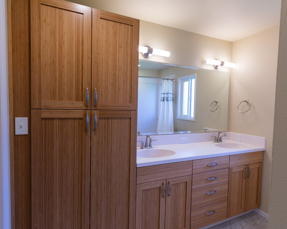 This is an example of a mid-sized contemporary kids bathroom in Other with shaker cabinets, medium wood cabinets, an alcove tub, a shower/bathtub combo, a two-piece toilet, beige walls, linoleum floors, an integrated sink, solid surface benchtops, grey floor, a shower curtain and beige benchtops.