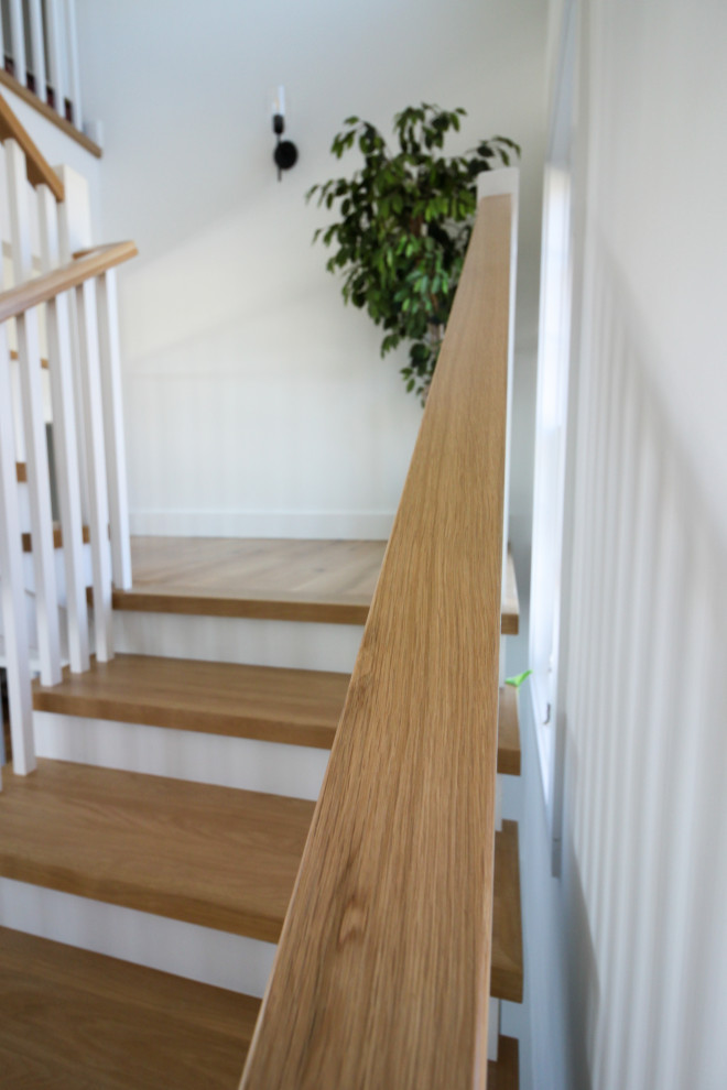 Foto de escalera en U campestre de tamaño medio con escalones de madera, contrahuellas de madera, barandilla de madera y machihembrado