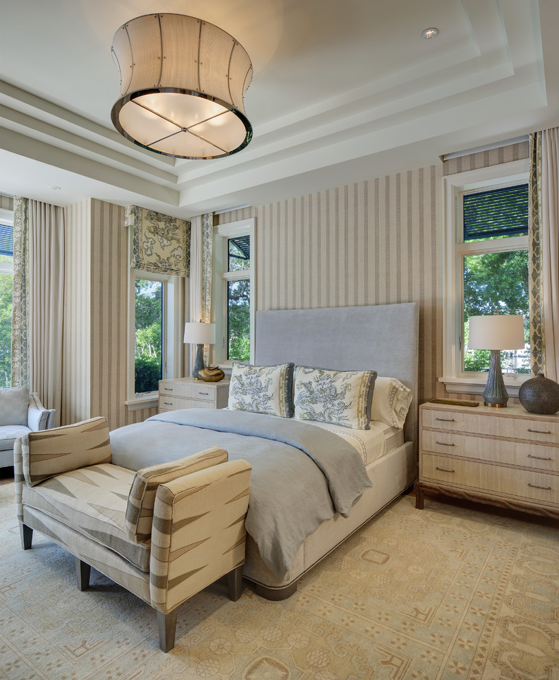 Photo of a large beach style guest bedroom in Miami with beige walls and carpet.