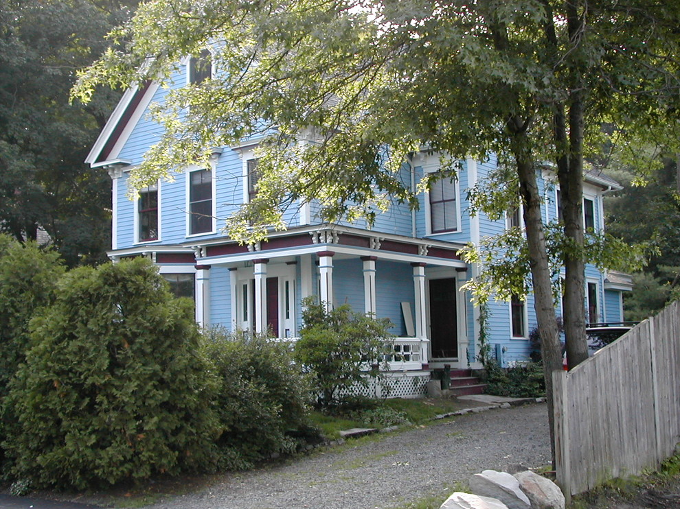 This is an example of a large traditional three-storey blue exterior in Boston with wood siding and a gable roof.