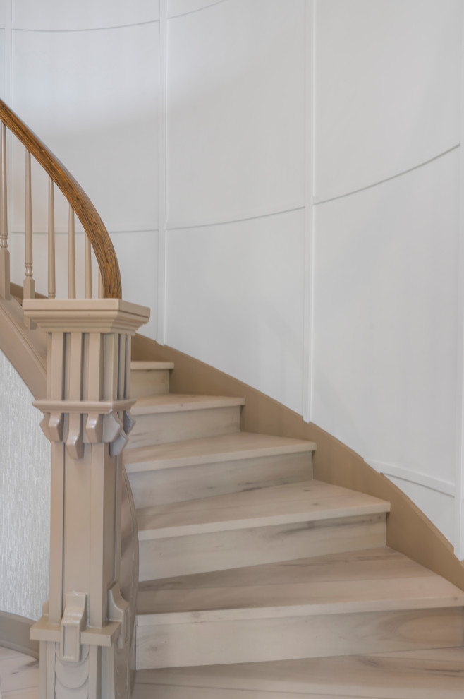 Свежая идея для дизайна: большая изогнутая деревянная лестница в классическом стиле с деревянными ступенями, деревянными перилами и панелями на стенах - отличное фото интерьера