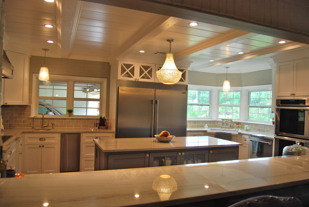 Inspiration for a mid-sized transitional u-shaped light wood floor kitchen remodel in Austin with a farmhouse sink, shaker cabinets, white cabinets, quartzite countertops, beige backsplash, porcelain backsplash, stainless steel appliances and an island