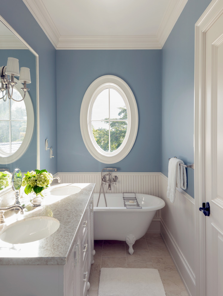 Inspiration for a large coastal 3/4 gray tile and stone tile marble floor claw-foot bathtub remodel in Miami with recessed-panel cabinets, white cabinets, granite countertops, blue walls and an undermount sink