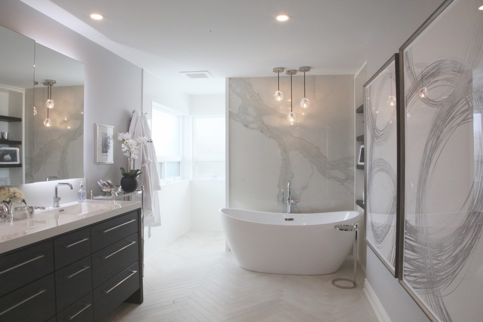 Photo of a mid-sized modern master bathroom in Toronto with flat-panel cabinets, dark wood cabinets, a freestanding tub, an open shower, a one-piece toilet, white tile, glass sheet wall, grey walls, porcelain floors, an integrated sink, quartzite benchtops, beige floor, an open shower and white benchtops.