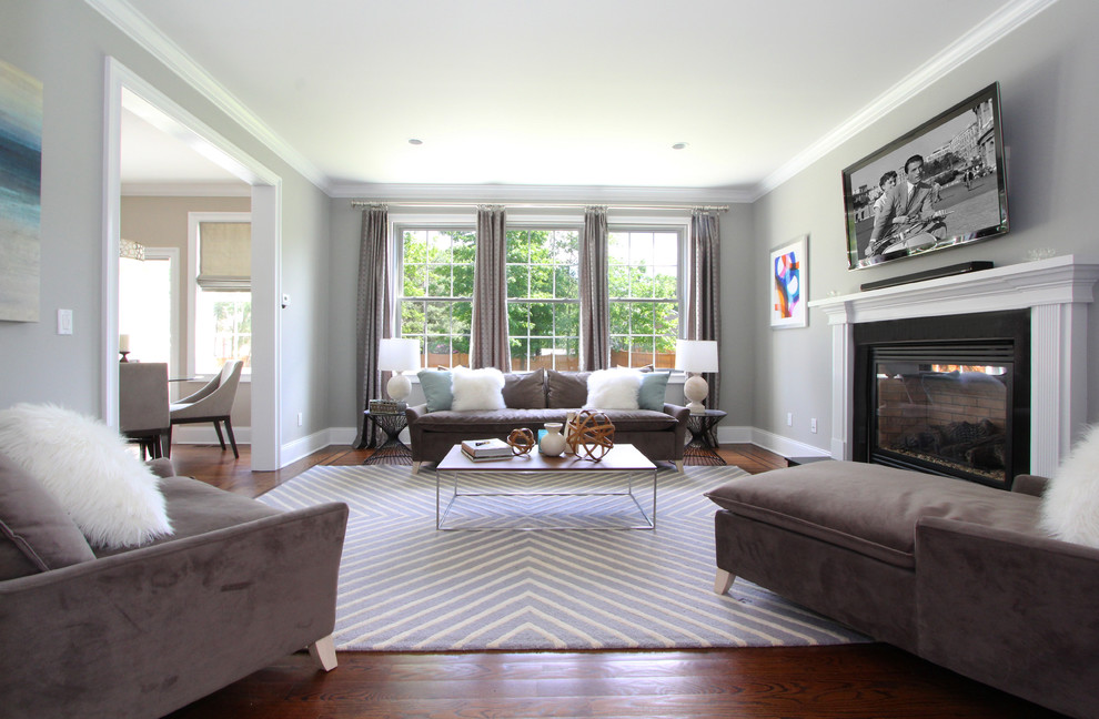 This is an example of a mid-sized modern open concept family room in New York with grey walls, medium hardwood floors and a standard fireplace.