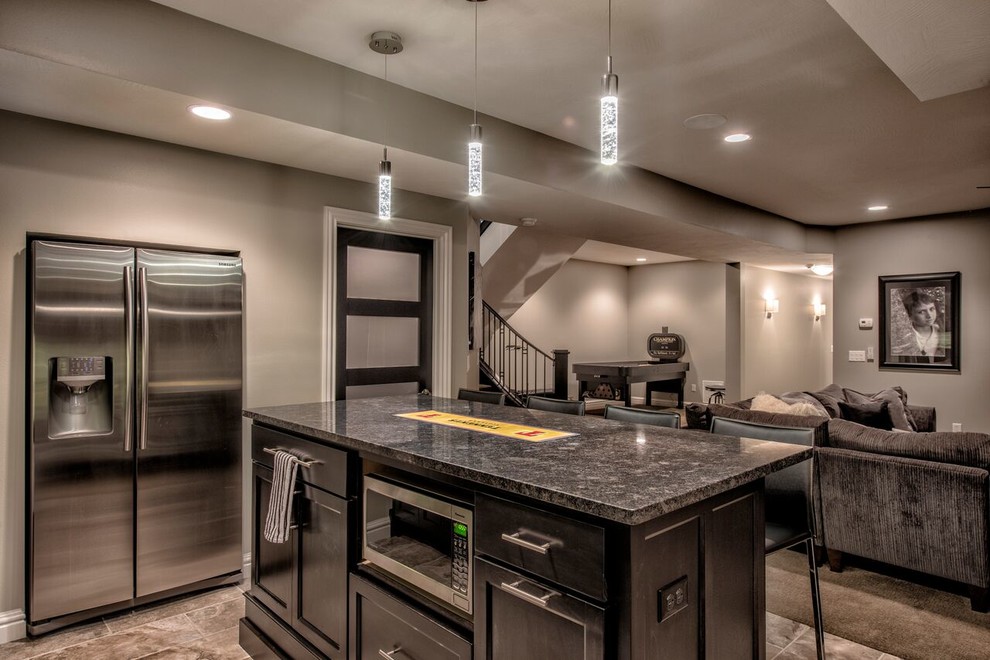 Example of a large transitional single-wall porcelain tile home design design with an undermount sink, glass-front cabinets, black cabinets, granite countertops, gray backsplash and glass tile backsplash
