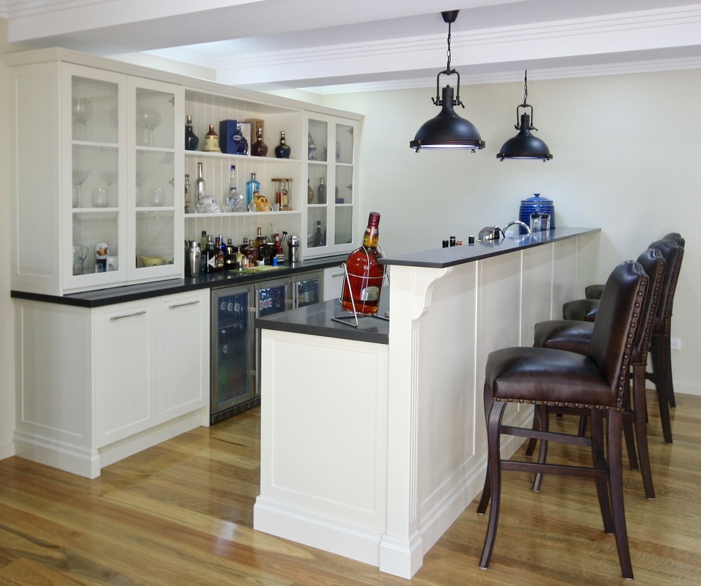 Design ideas for a mid-sized transitional galley seated home bar in Sydney with a drop-in sink, shaker cabinets, beige cabinets, quartz benchtops and medium hardwood floors.