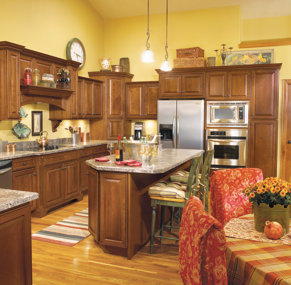 Eat-in kitchen - large traditional light wood floor eat-in kitchen idea with raised-panel cabinets, medium tone wood cabinets, stainless steel appliances, an island and a drop-in sink