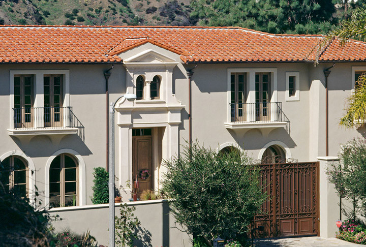 Inspiration for a large mediterranean two-storey stucco beige house exterior in San Diego with a hip roof and a tile roof.