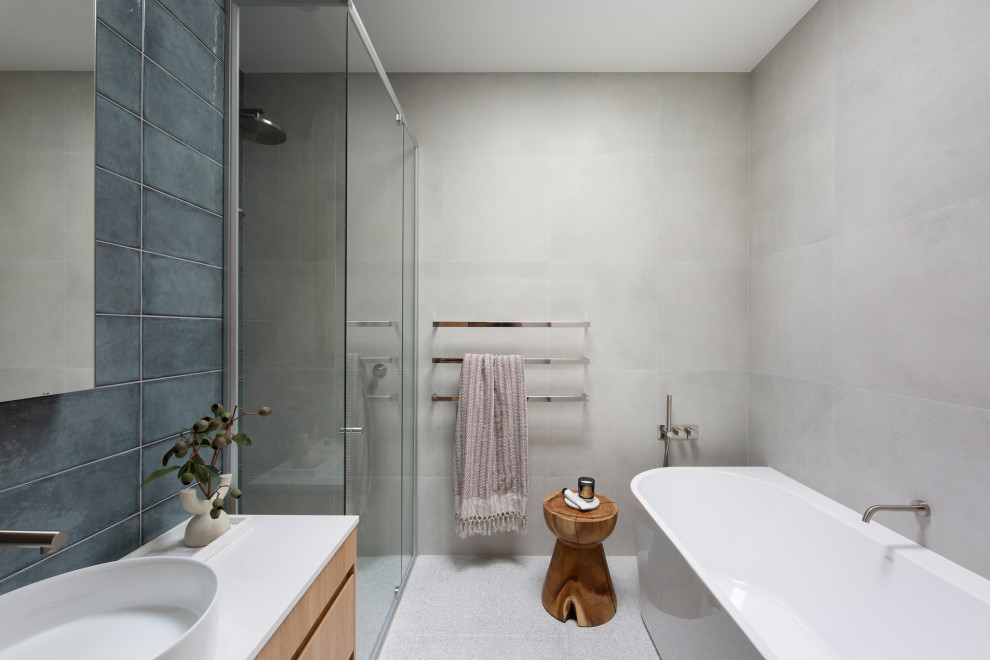 Modern inredning av ett mellanstort vit vitt badrum med dusch, med skåp i ljust trä, ett fristående badkar, en öppen dusch, grön kakel, porslinskakel, klinkergolv i porslin, ett fristående handfat, bänkskiva i kvarts, grått golv och dusch med gångjärnsdörr