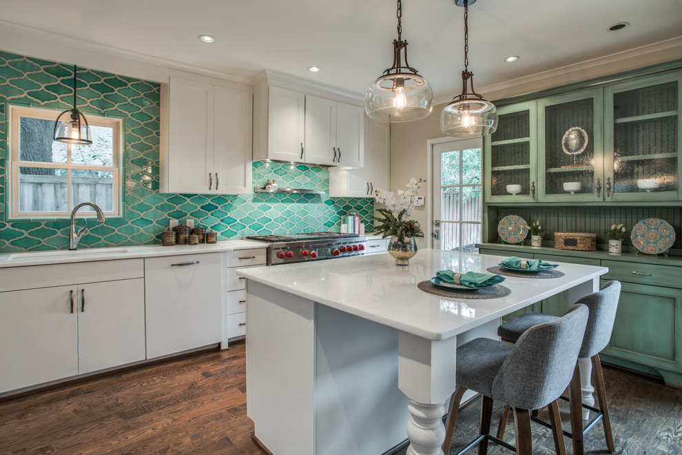 Design ideas for a mid-sized transitional l-shaped eat-in kitchen in Dallas with a single-bowl sink, shaker cabinets, white cabinets, marble benchtops, green splashback, porcelain splashback, stainless steel appliances, medium hardwood floors, with island and brown floor.