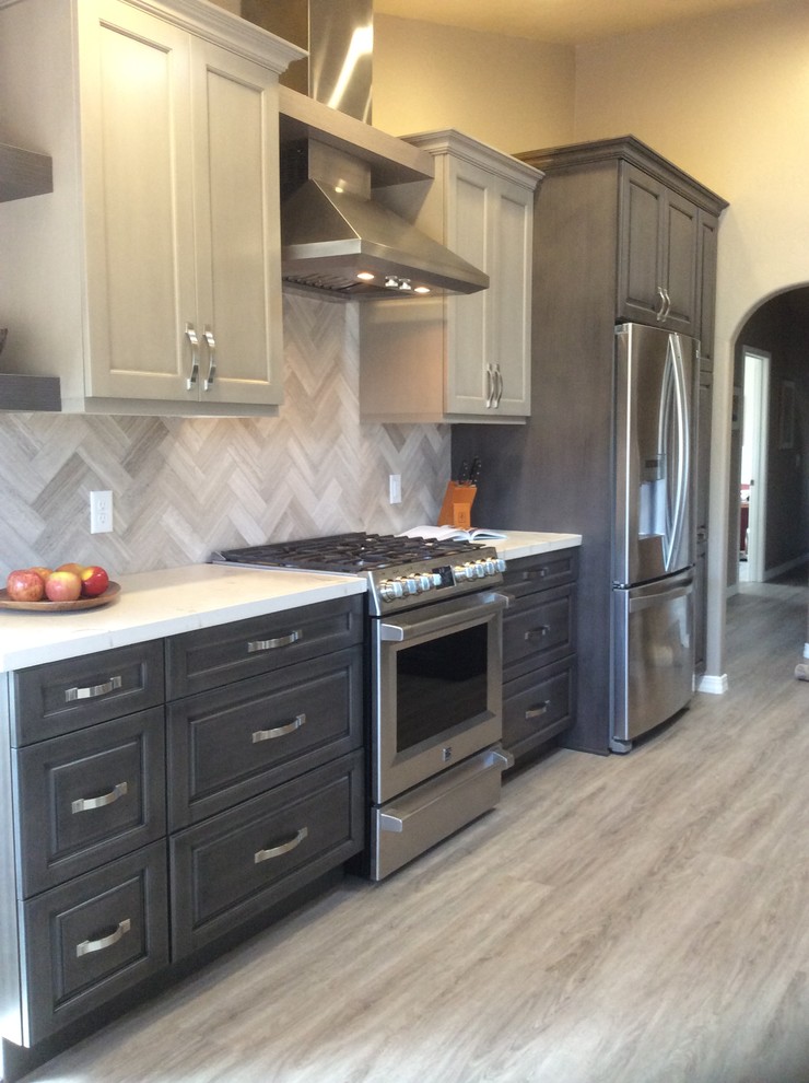 Mid-sized transitional dark wood floor and brown floor kitchen photo in Phoenix with raised-panel cabinets, dark wood cabinets, onyx countertops, brown backsplash, ceramic backsplash, stainless steel appliances and an island