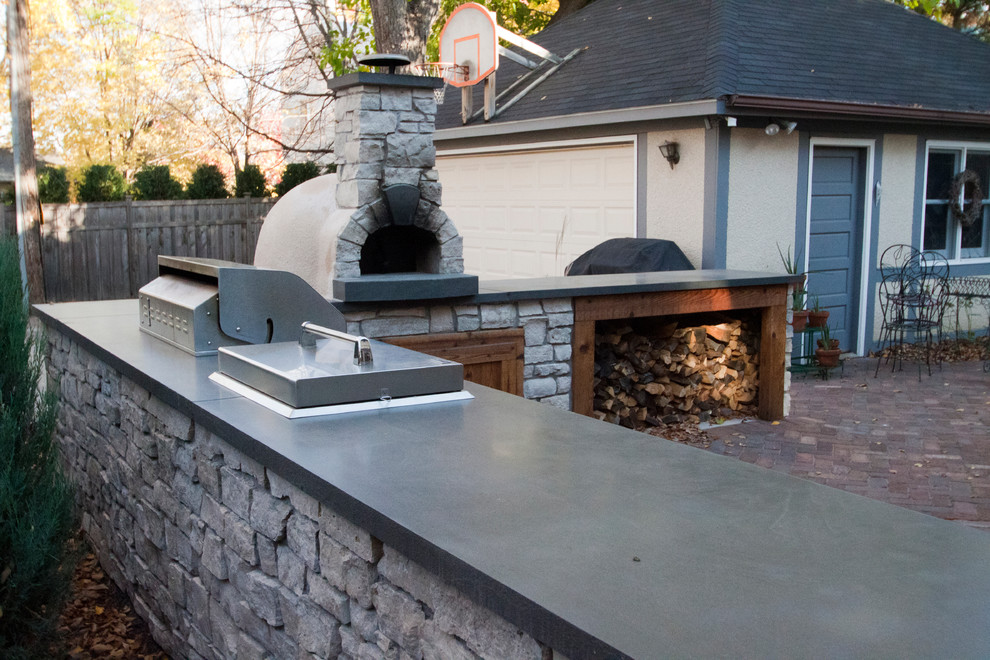 Inspiration for a mid-sized traditional backyard patio in Minneapolis with an outdoor kitchen, brick pavers and no cover.
