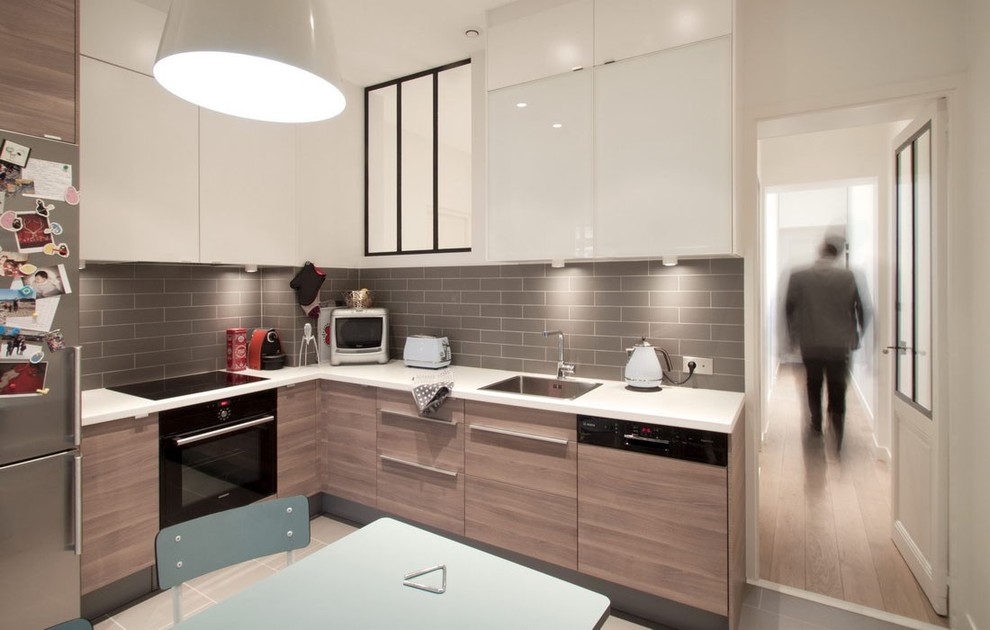 Design ideas for a mid-sized contemporary l-shaped eat-in kitchen in Paris with a single-bowl sink, light wood cabinets, grey splashback, panelled appliances, ceramic floors and no island.