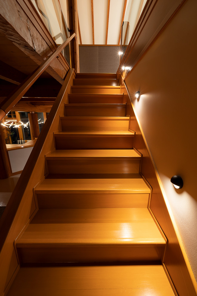 Mittelgroße Moderne Holztreppe mit Holz-Setzstufen, Stahlgeländer und Wandpaneelen in Vancouver