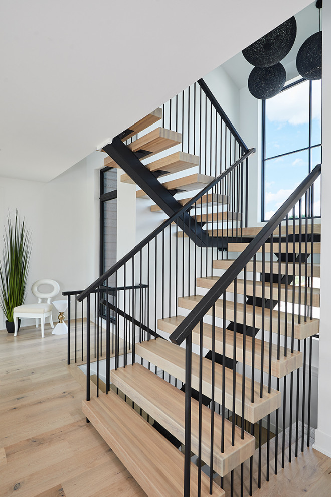 Imagen de escalera en L actual grande sin contrahuella con escalones de madera y barandilla de metal