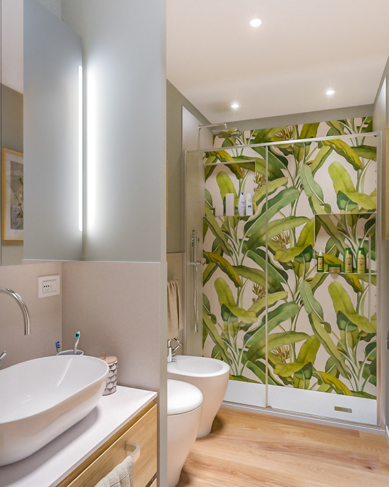 This is an example of a small contemporary 3/4 bathroom in Milan with flat-panel cabinets, light wood cabinets, an alcove shower, a two-piece toilet, multi-coloured tile, porcelain tile, green walls, light hardwood floors, a vessel sink, laminate benchtops, a sliding shower screen, white benchtops, a single vanity, a floating vanity and recessed.