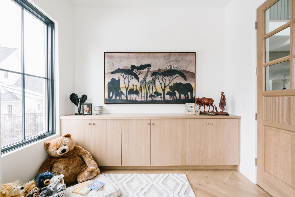 Photo of a mid-sized transitional gender-neutral kids' room in Salt Lake City with white walls, light hardwood floors and brown floor.