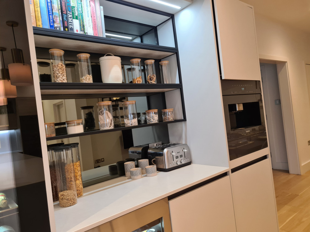 Foto de cocina comedor actual grande con fregadero de un seno, armarios con paneles lisos, puertas de armario grises, encimera de cuarzo compacto, salpicadero blanco, puertas de cuarzo sintético, electrodomésticos con paneles, suelo de madera clara, una isla, suelo beige y encimeras grises