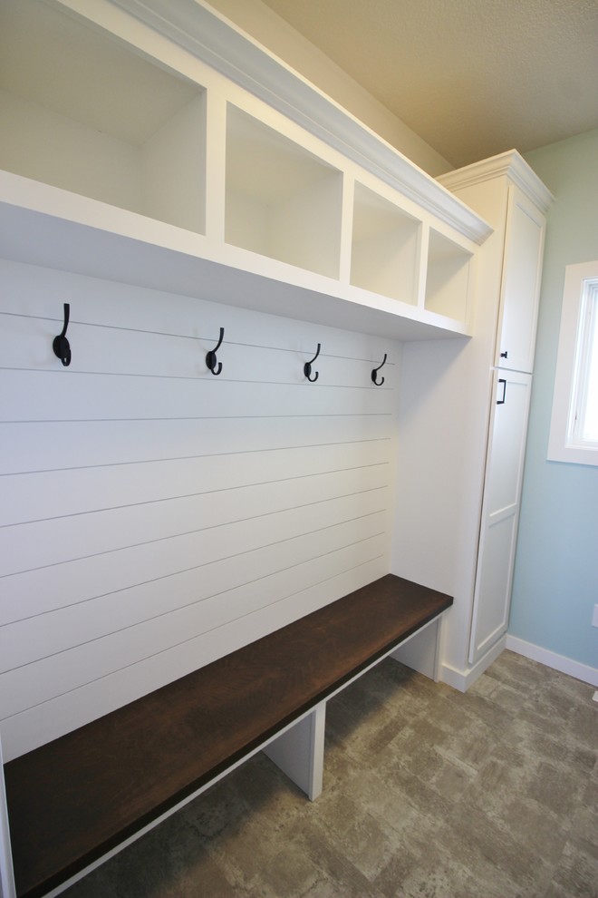 Country laundry room in Minneapolis with shaker cabinets, white cabinets and blue walls.