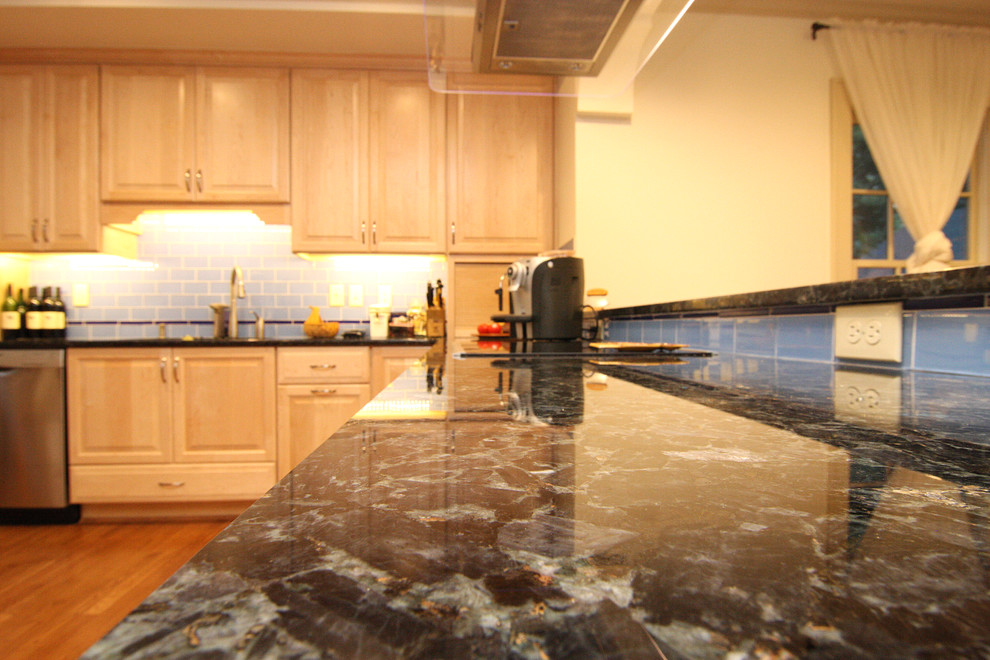 Home design - huge transitional l-shaped medium tone wood floor home design idea with an undermount sink, raised-panel cabinets, light wood cabinets, granite countertops, blue backsplash, glass tile backsplash and stainless steel appliances