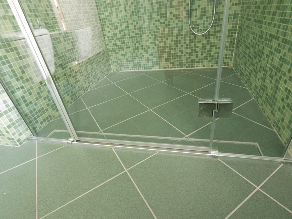 Cette image montre une petite douche en alcôve principale minimaliste avec un plan vasque, WC séparés, un carrelage vert, mosaïque, un mur vert et un sol en carrelage de céramique.