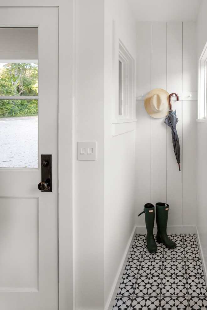Design ideas for a small scandinavian mudroom in Boston with white walls, ceramic floors, a single front door, a white front door, multi-coloured floor and planked wall panelling.
