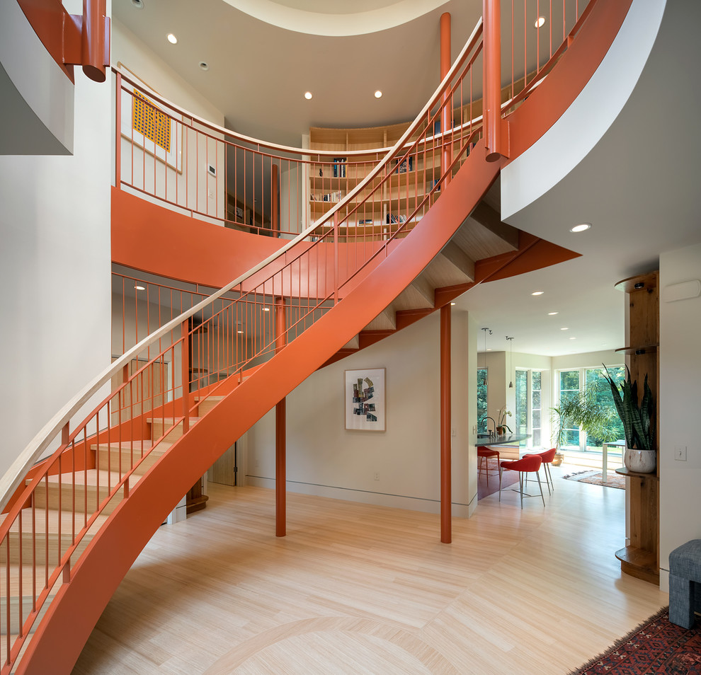 Inspiration for a large contemporary wood curved staircase in Boston with wood risers and metal railing.