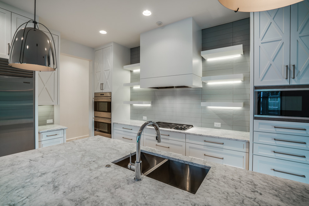Example of a large transitional single-wall light wood floor kitchen design in Dallas with a double-bowl sink, shaker cabinets, white cabinets, marble countertops, white backsplash, stainless steel appliances and an island