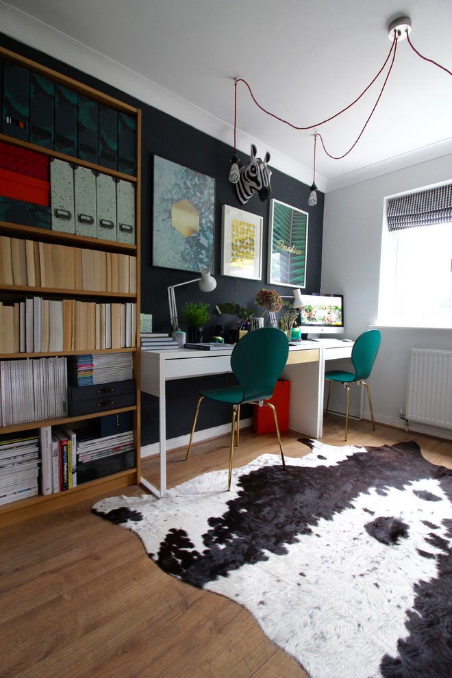 Design ideas for a small eclectic study room in Surrey with black walls, laminate floors, a freestanding desk and brown floor.