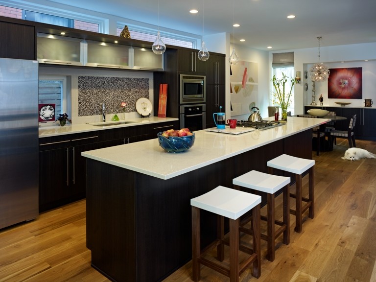Contemporary single-wall eat-in kitchen in Denver with an undermount sink, flat-panel cabinets, dark wood cabinets, multi-coloured splashback, stainless steel appliances, light hardwood floors and with island.