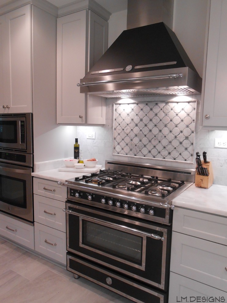 Transitional galley porcelain tile eat-in kitchen photo with a farmhouse sink, recessed-panel cabinets, gray cabinets, marble countertops, stone tile backsplash and stainless steel appliances