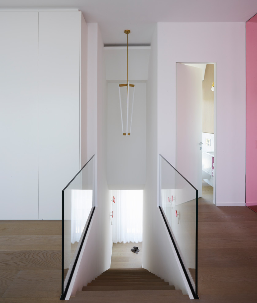 Идея дизайна: деревянная лестница среднего размера в современном стиле с деревянными ступенями и стеклянными перилами