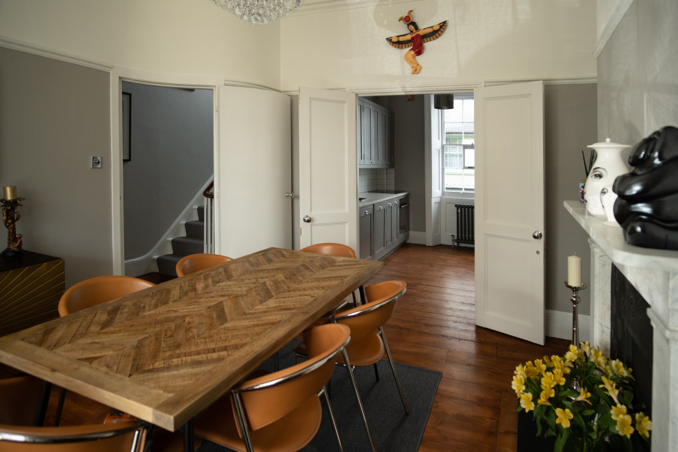 Foto på ett stort funkis kök med matplats, med grå väggar, mellanmörkt trägolv, en standard öppen spis, en spiselkrans i sten och brunt golv